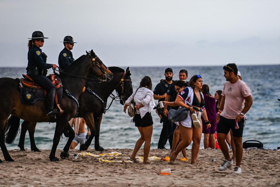 Fort Lauderdale Mounted Police officers escort revelers off the beach in March 2022.