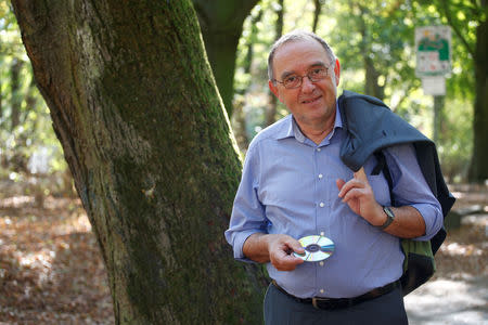 Norbert Walter-Borjans, former finance minister of the federal state of North Rhine-Westphalia (NRW) holds a blank CD during a photo session with Reuters in a park in his hometown in Cologne, Germany, October 13, 2018. REUTERS/Wolfgang Rattay