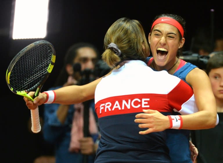 France's Caroline Garcia (R) is congratulated by her captain Amelie Mauresmo on April 17, 2016