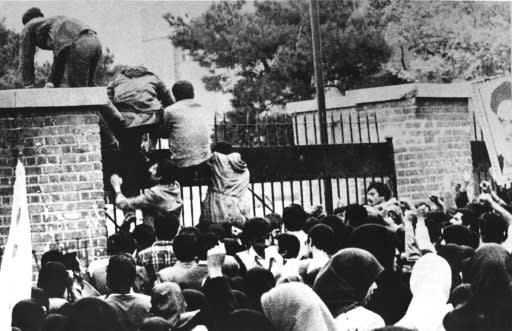 Iranian revolutionary students climb the American embassy's gate in Tehran on November 4, 1979 less than nine months after the toppling of the US-backed shah