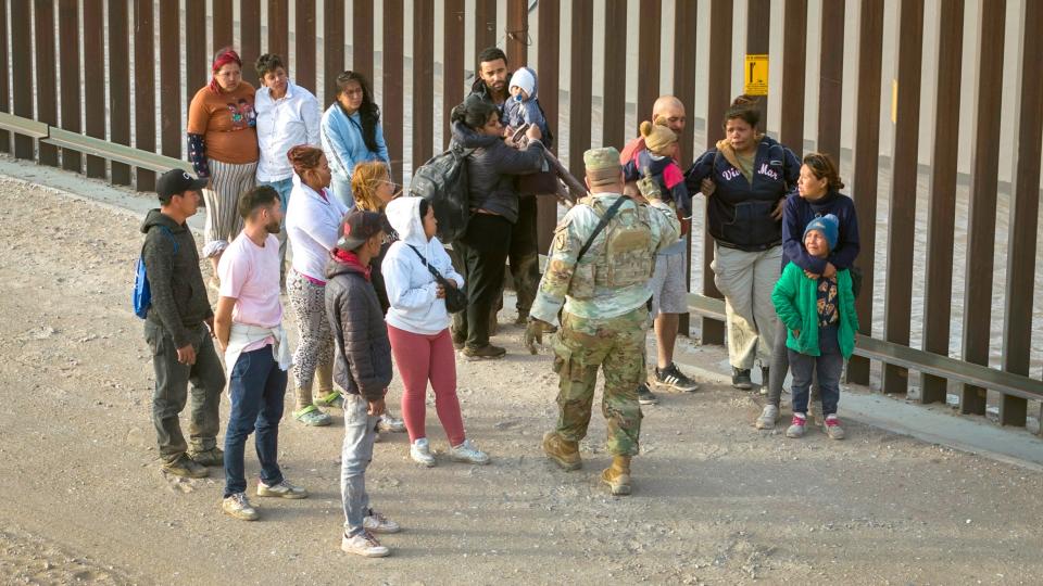 A Texas National Guard soldier counts migrants after they crossed the U.S.-Mexico border to request asylum on March 13, 2024, in El Paso, Texas.