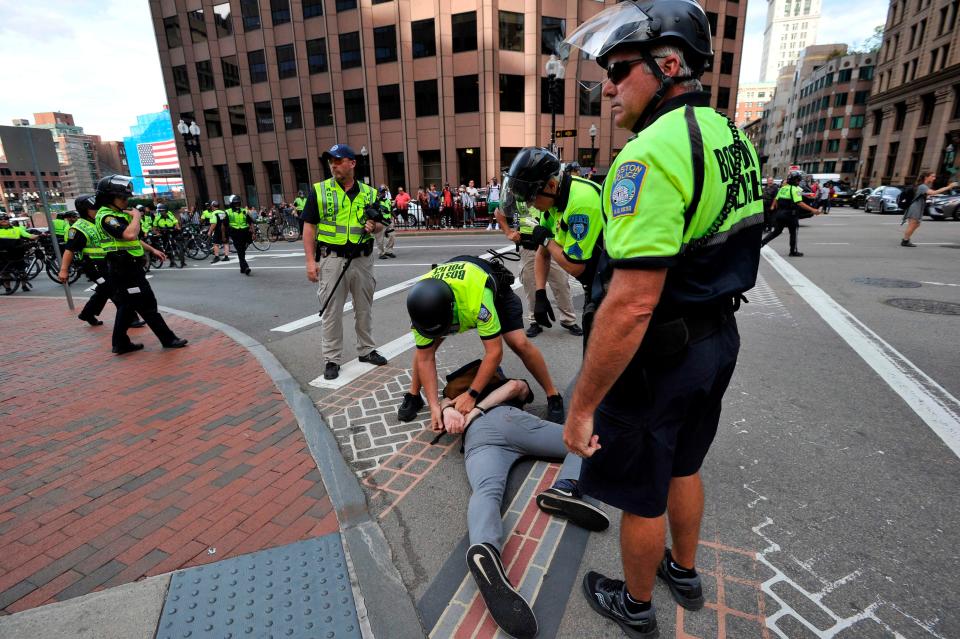 Boston Police officers arrest an anti-parade demonstrator during the 