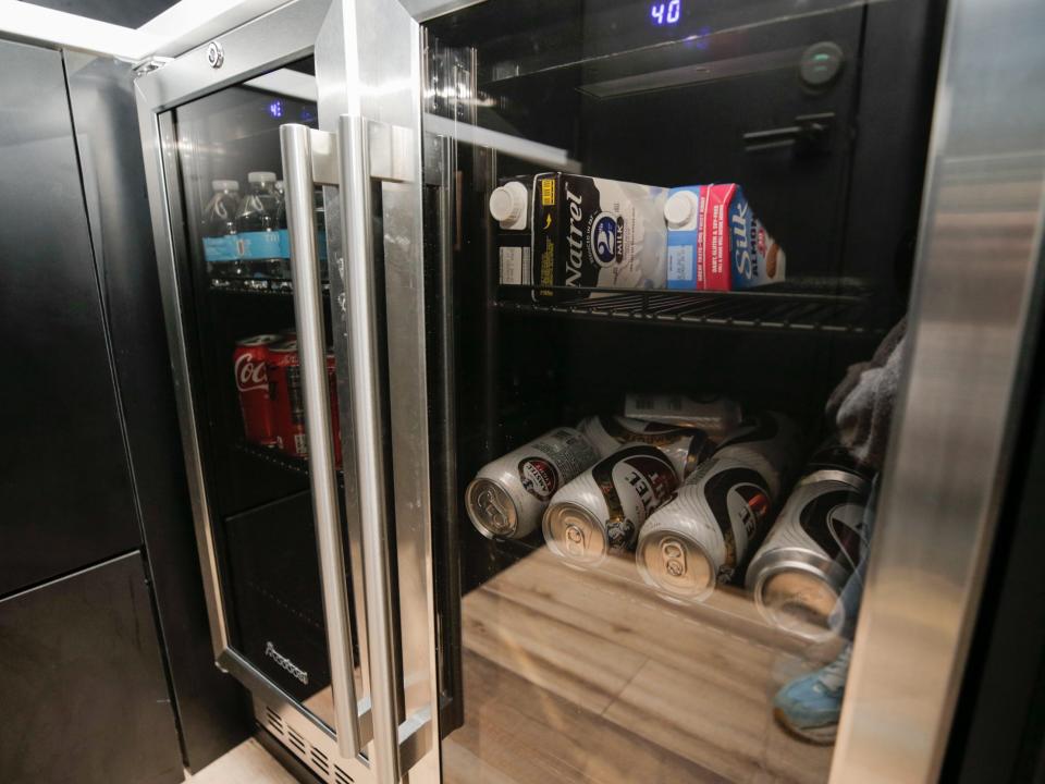 A fridge with tinted windows and drinks inside.