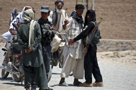 Afghan policemen search people near the house of the cousin of Afghan President Hamid Karzai, Hashmat Karzai, at the site of a suicide attack in Kandahar July 29, 2014. REUTERS/Ahmad Nadeem