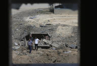 Palestinians inspect the rubble of an ice factory and mechanics garages destroyed by an Israeli airstrikes, in Gaza City, Tuesday, May 11, 2021. (AP Photo/Adel Hana)