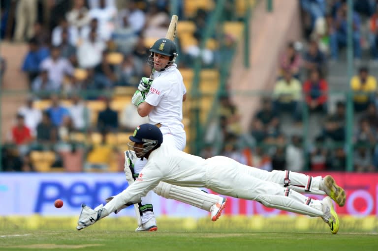 India's Wriddhiman Saha (R) takes the catch to dismiss South Africa's AB de Villiers for 85 runs during the first day of the second Test in Bangalore on November 14, 2015