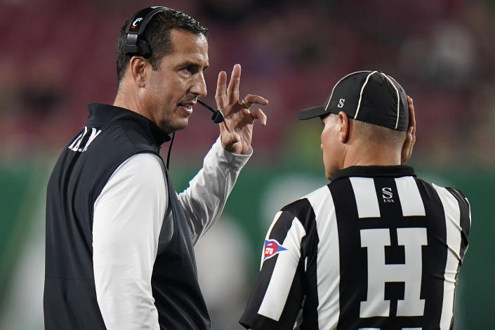 Cincinnati head coach Luke Fickell talks to head linesman Baron Ballester during the second half of an NCAA college football game against South Florida Friday, Nov. 12, 2021, in Tampa, Fla. (AP Photo/Chris O'Meara)