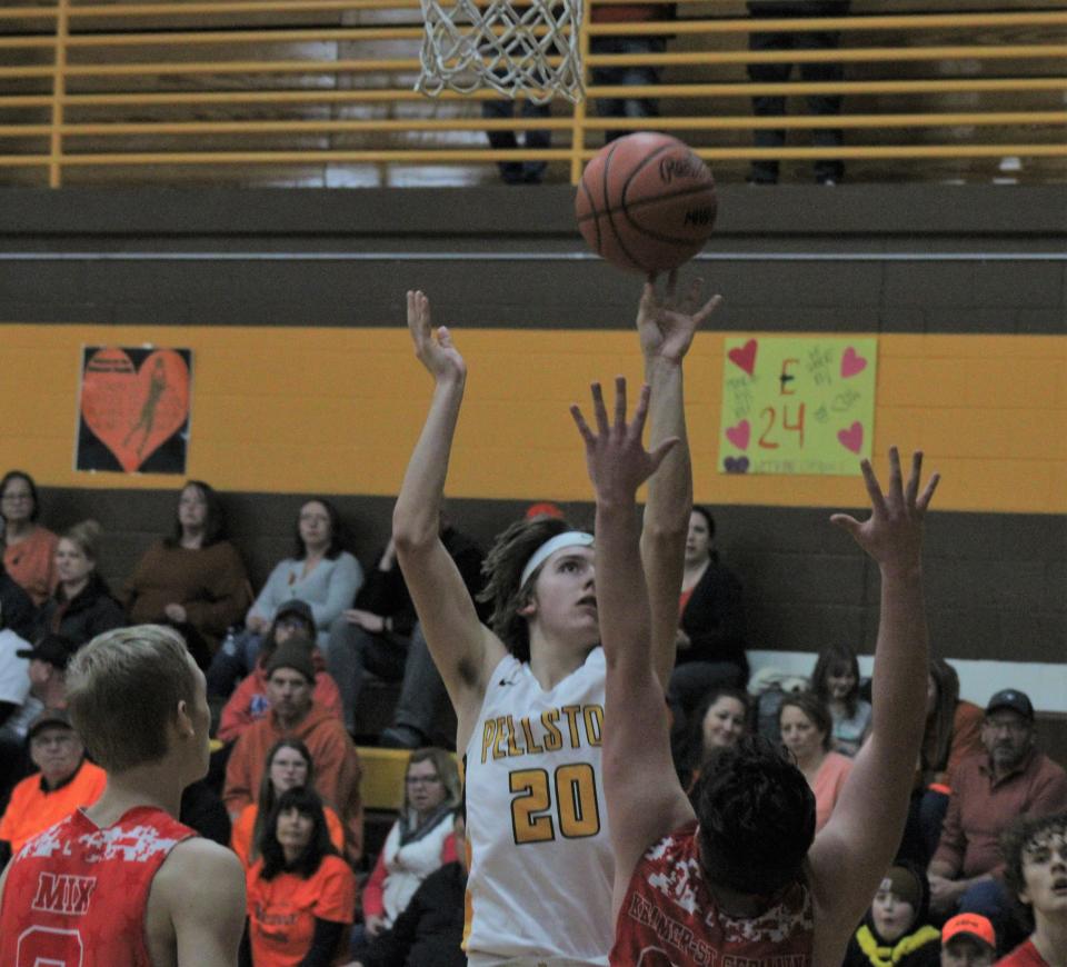 Pellston sophomore Brach Taylor (20) puts up a shot over Onaway defenders during the first half on Tuesday.