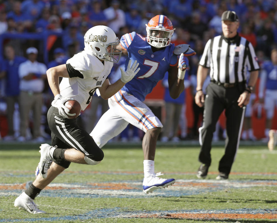 Idaho quarterback Mason Petrino scrambles out of the pocket as he is pressured by Florida linebacker Jeremiah Moon (7) during the second half of an NCAA college football game, Saturday, Nov. 17, 2018, in Gainesville, Fla. (AP Photo/John Raoux)