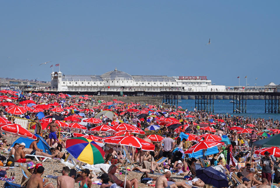 People enjoy the warm weather at Brighton beach in West Sussex. Picture date: Sunday July 10, 2022.