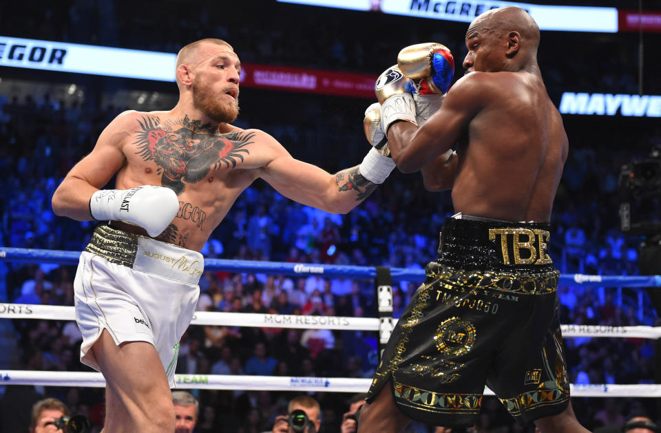 LAS VEGAS, NV - AUGUST 26:  (L-R) Conor McGregor throws a punch at Floyd Mayweather Jr. during their super welterweight boxing match on August 26, 2017 at T-Mobile Arena in Las Vegas, Nevada.  (Photo by Josh Hedges/Zuffa LLC/Zuffa LLC via Getty Images )