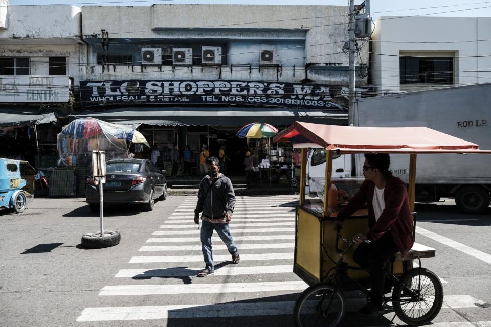 A commuter cross a pedestrian lane near the market in General Santos, the Philippines, on Wednesday, Aug. 24, 2022. The Philippine central bank's series of interest-rate hikes have likely contained inflation, Governor Felipe Medalla said, as he signaled a more gradual tightening path for the rest of the year.