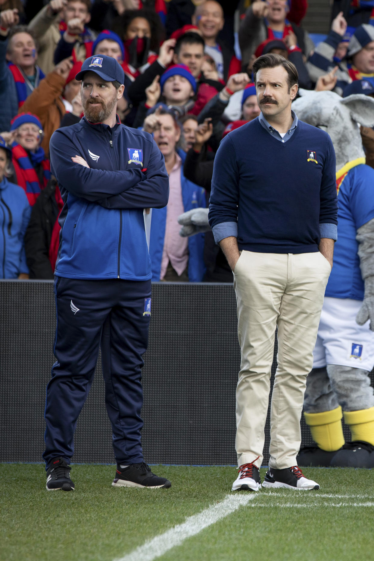 Imagen sin fecha de Apple TV+, donde Brendan Hunt y Jason Sudeikis están frente a una multitud en “Ted Lasso”. (Apple TV+ vía The New York Times)