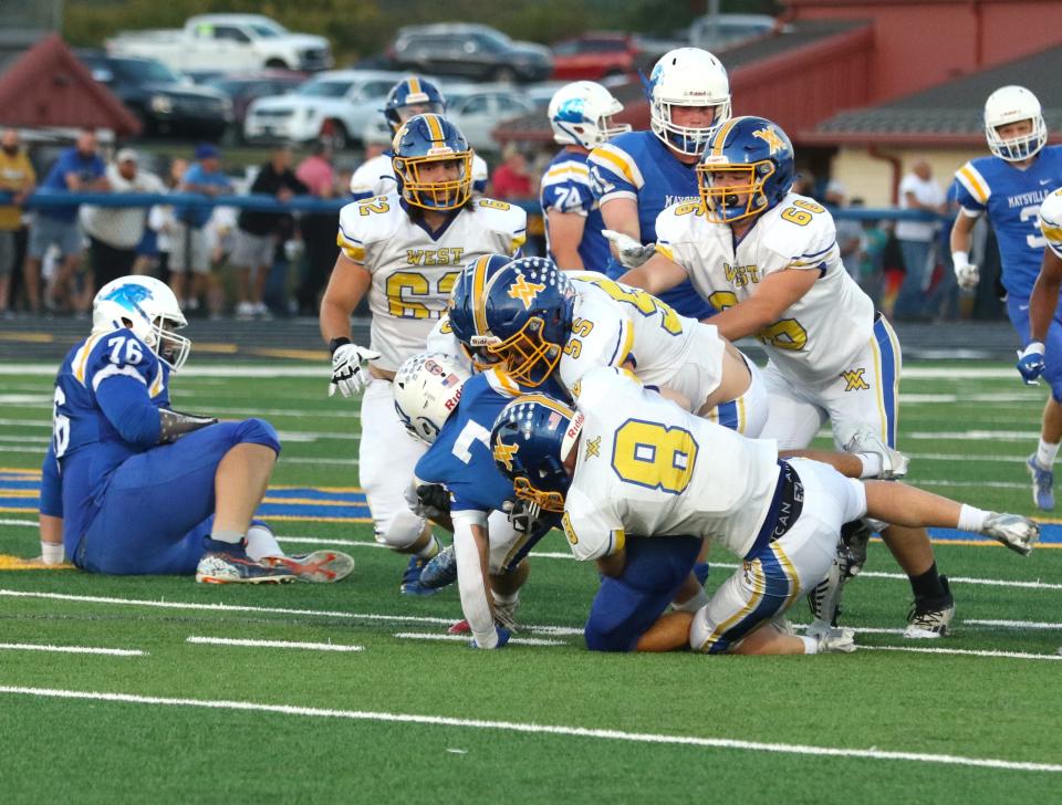 West Muskingum's Keegan Karns (8) and Cord McKenzie (55) stuff Maysville's Wesley Armstead in a 42-0 win two weeks ago. The Tornado defense has posted three straight shutouts entering Friday's game at Morgan.