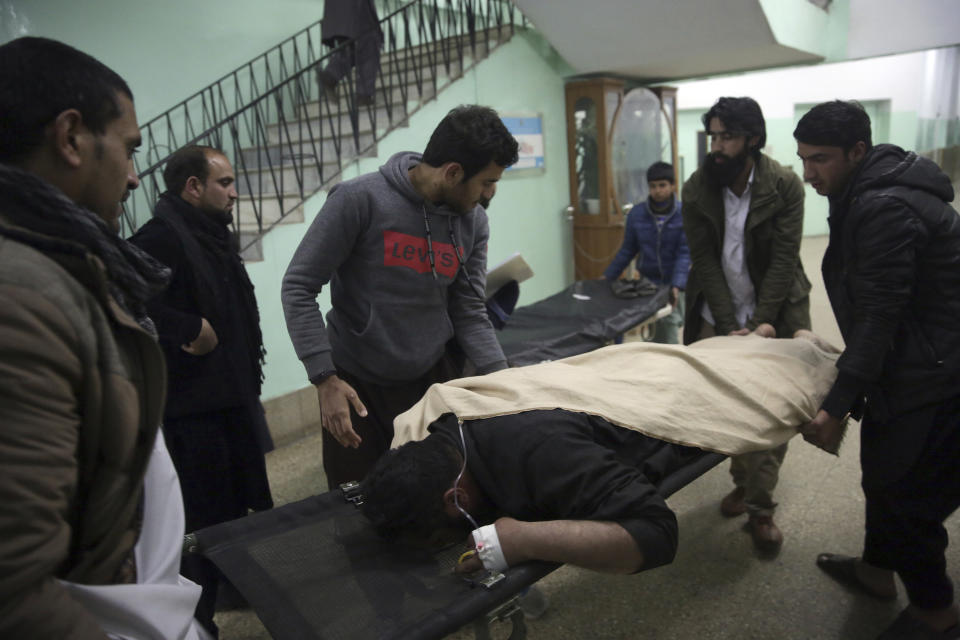 Men assist a wounded relative in a hospital in Kabul, Afghanistan, Monday, Jan. 14, 2019. Afghan officials say multiple people were killed when a suicide bomber detonated a vehicle full of explosive in the capital Kabul on Monday. (AP Photo/Massoud Hossaini)