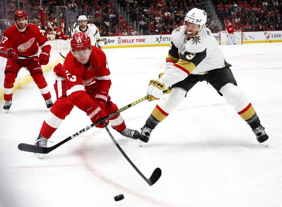 Vegas Golden Knights defenseman Brayden McNabb (3) hits the hand of Detroit Red Wings left wing Lucas Raymond (23) as they chase the puck during the first period of an NHL hockey game Saturday, Jan. 27, 2024, in Detroit. (AP Photo/Duane Burleson)