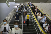 Commuters wearing face masks to protect against the spread of the new coronavirus walk through a subway station in Beijing, Thursday, July 9, 2020. (AP Photo/Mark Schiefelbein)