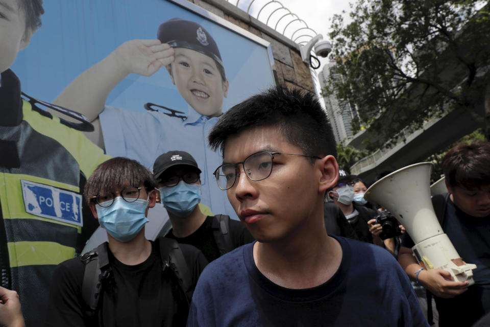 Pro-democracy activist Joshua Wong, foreground, joins other protesters to surround the police headquarters in Hong Kong on Friday, June 21, 2019. Several hundred mainly student protesters gathered outside Hong Kong government offices Friday morning, with some blocking traffic on a major thoroughfare, after a deadline passed for meeting their demands related to controversial extradition legislation that many see as eroding the territory's judicial independence. (AP Photo/Kin Cheung)