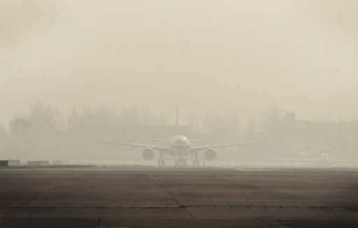 An aircraft at Beijing International Airport sits on the tarmac in heavy smog in December 2011. Beijing's government on Friday bowed to a vocal online campaign for a change in the way air quality is measured in the Chinese capital, one of the world's most polluted cities