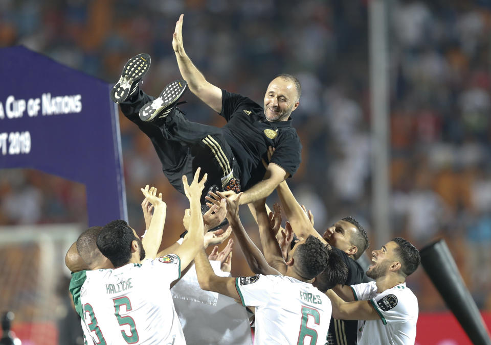 Algerian players throw their coach Djamel Belmadiin the air after the African Cup of Nations final soccer match between Algeria and Senegal in Cairo International stadium in Cairo, Egypt, Friday, July 19, 2019. (AP Photo/Ariel Schalit)