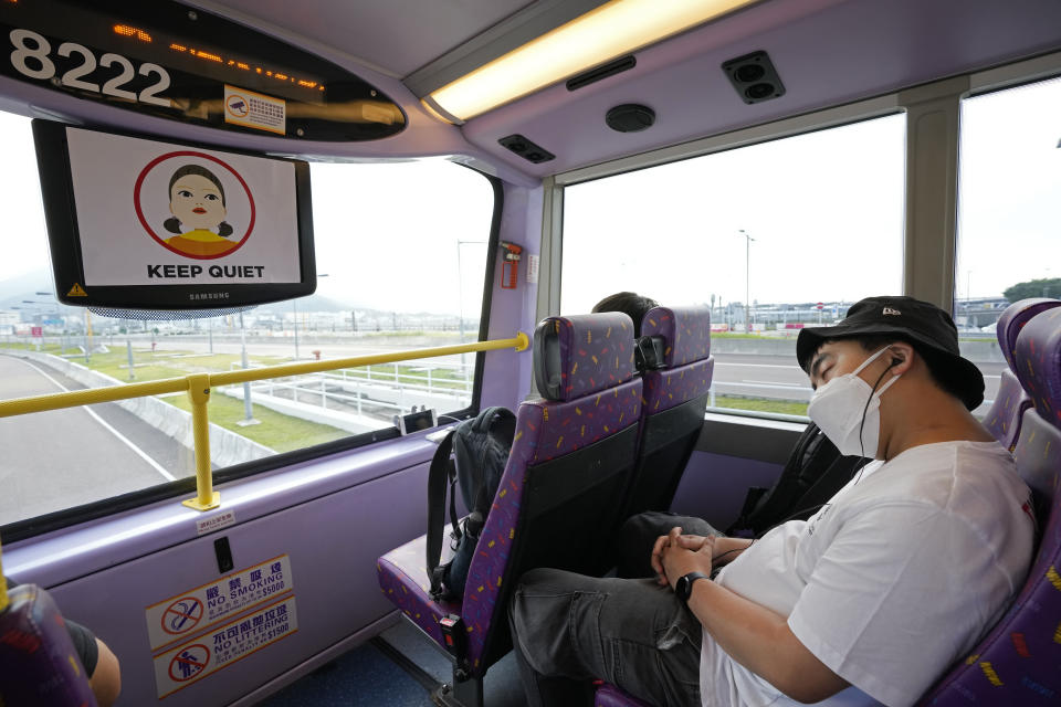 A passenger sleeps on the upper deck of a double-decker bus during a tour in Hong Kong, Saturday, Oct. 16, 2021. Travel-starved, sleep-deprived residents might find a new Hong Kong bus tour to be a snooze. The 76-kilometer (47-mile), five-hour ride on a regular double-decker bus around the territory is meant to appeal to people who are easily lulled asleep by long rides. It was inspired by the tendency of tired commuters to fall asleep on public transit. (AP Photo/Kin Cheung)