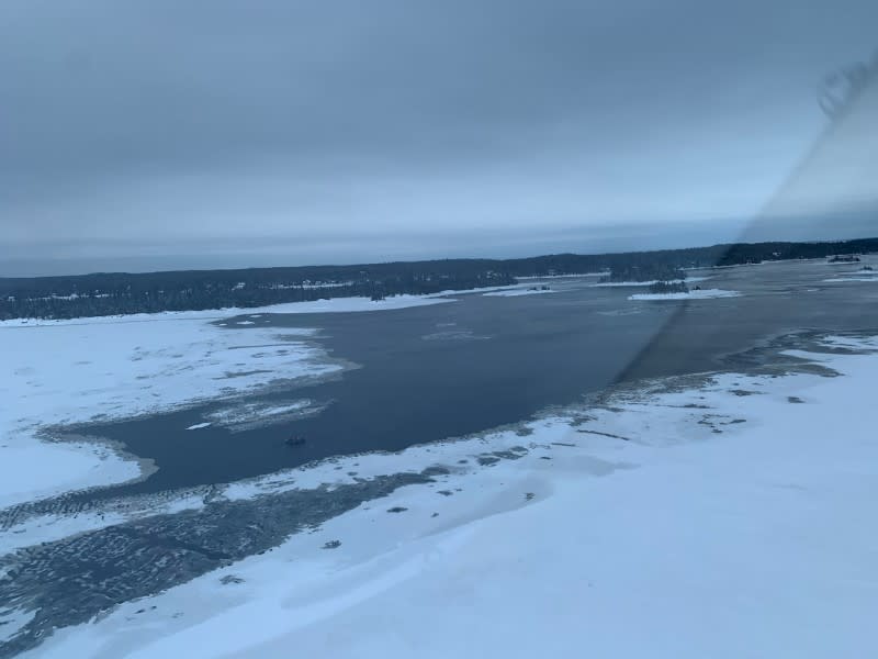 A helicopter carrying provincial police officers from the Surete du Quebec searches an area for five missing French snowmobilers on Lac-St-Jean