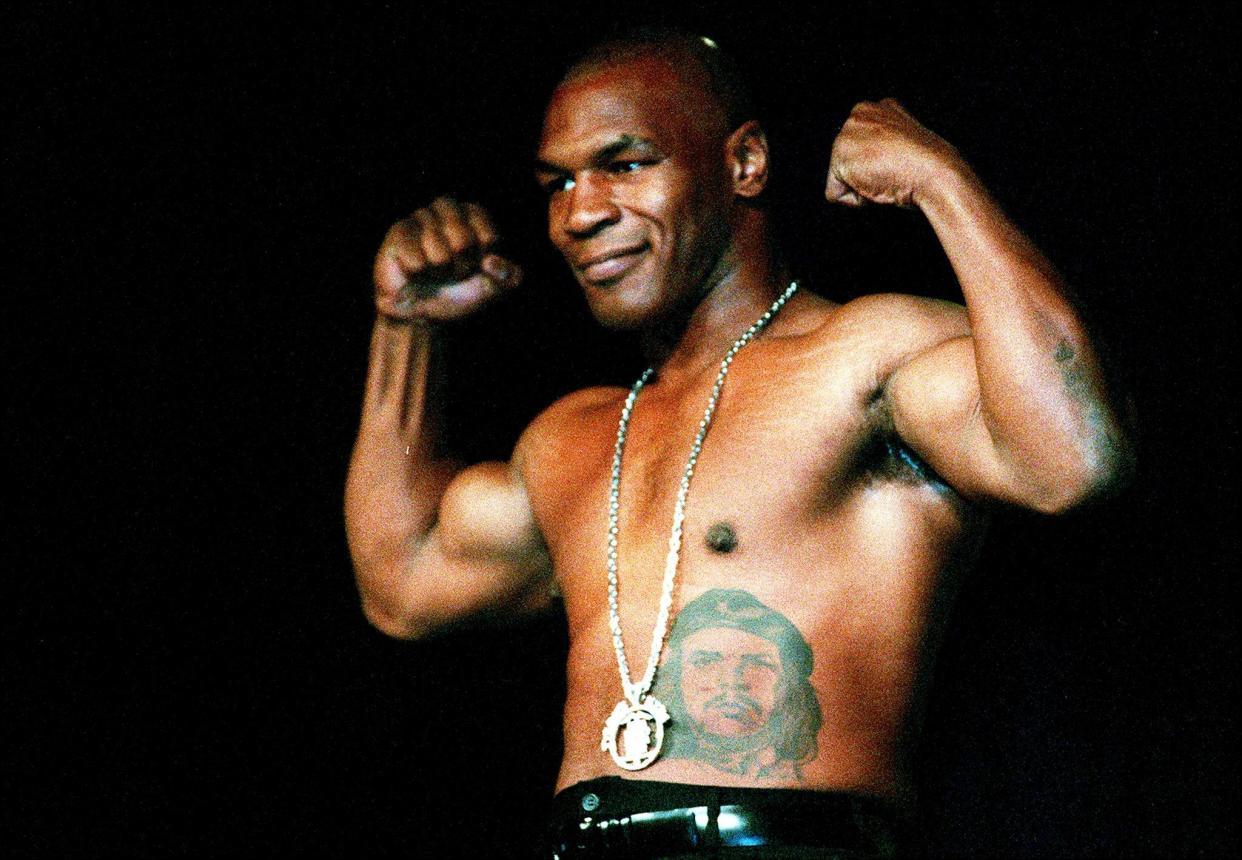 Mike Tyson pictured flexing his muscles in 2000 (Getty)