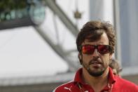 Ferrari Formula One driver Fernando Alonso of Spain arrives at the paddock before the first practice session of Singapore F1 Grand Prix September 19, 2014. REUTERS/Tim Chong