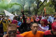 FILE - A labor activist holds up a smoke stick during a rally against fuel price hikes in Jakarta, Indonesia, Sept. 21, 2022. The war, and consequent rising gas prices, forced Indonesia to reduce ballooning subsidies aimed at keeping fuel prices and some power tariffs in check. (AP Photo/Tatan Syuflana, File)