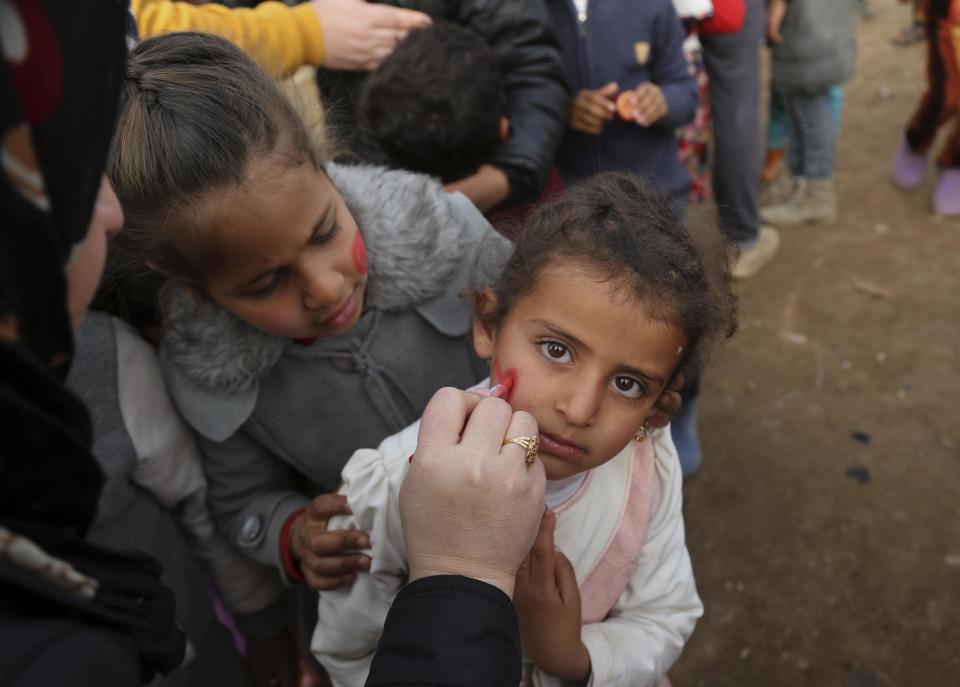 Iraqi internally displaced children having their faces painted during New Year's celebrations at the Hassan Sham camp, east of Mosul, Iraq, Saturday, Dec 31, 2016. (AP Photo/ Khalid Mohammed)