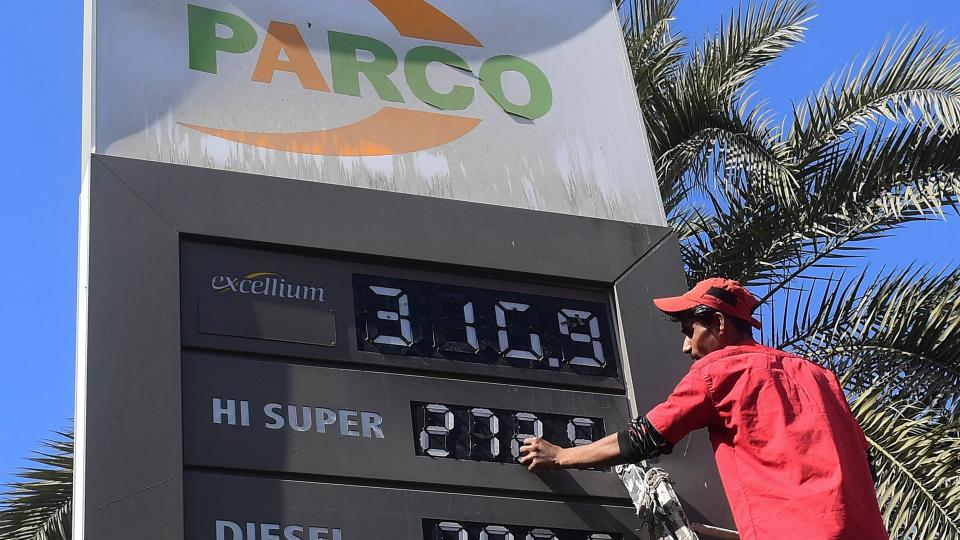 An employee of a petrol station updates the latest fuel prices on a board in Karachi on February 16, 2023, after a hike in prices of petroleum products by the government.