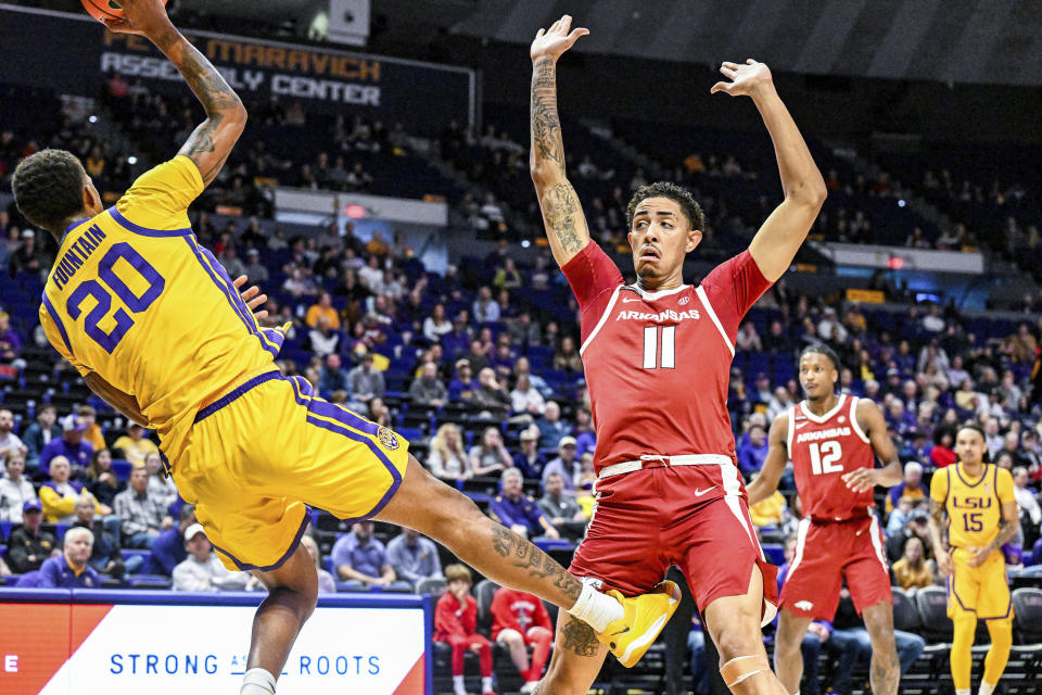 LSU forward Derek Fountain (20) makes a pass as he falls out of bounds while guarded by Arkansas forward Jalen Graham (11) during an NCAA college basketball game at Pete Maravich Assembly Center, Saturday, Feb. 3, 2024, Baton Rouge, La. (Javier Gallegos/The Advocate via AP)