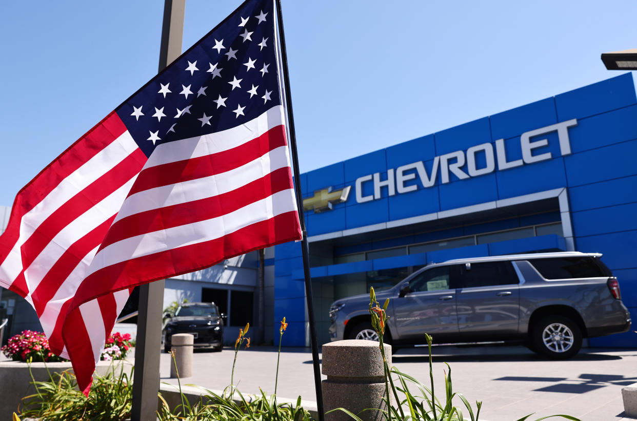 GLENDALE, CALIFORNIA - AUGUST 04: An American flag flies at a Chevrolet dealership on August 4, 2021 in Glendale, California. In spite of a computer chip shortage, General Motors (GM) posted a $2.8 billion net profit in the second quarter. (Photo by Mario Tama/Getty Images)