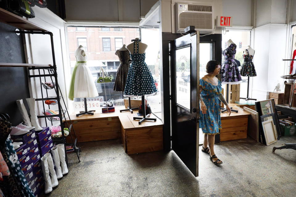 Becca Clark walks into the front entrance of her newly relocated vintage clothing and jewelry store, Tuesday, July 16, 2019, in Davenport, Iowa. Hundreds of communities line the Mississippi River, but Davenport is among the few where people can dip their toes into the water without scaling a flood wall or levee. (AP Photo/Charlie Neibergall)