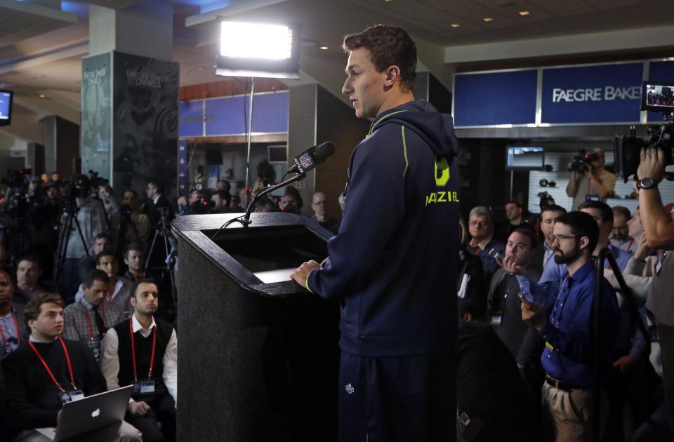 Texas A&M quarterback Johnny Manziel is surrounded by the media as answers a question during a news conference at the NFL football scouting combine in Indianapolis, Friday, Feb. 21, 2014. (AP Photo/Michael Conroy)