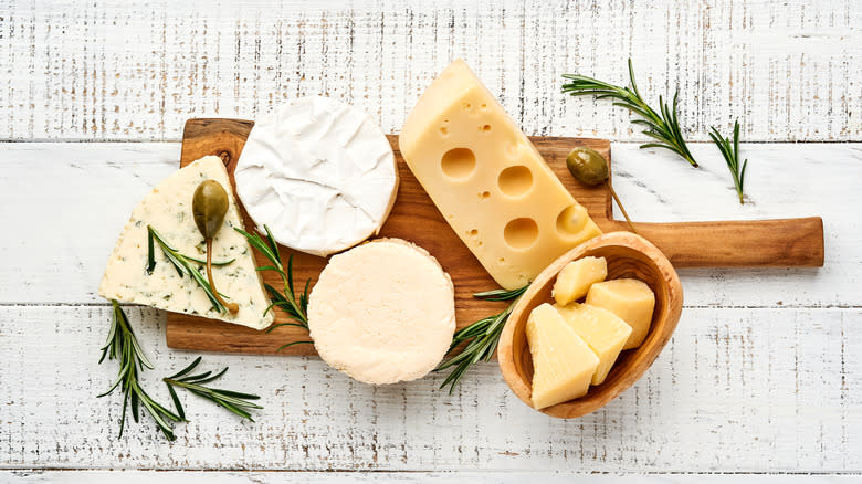 cutting board with cheese and herbs