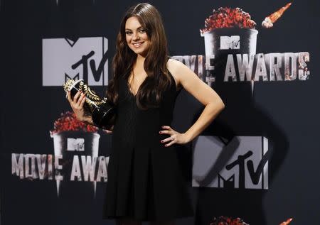 Actress Mila Kunis poses backstage with her Best Villian award as Theodora, Wicked Witch of the West, in the film "Oz the Great and Powerful" during the 2014 MTV Movie Awards in Los Angeles, California April 13, 2014. REUTERS/Danny Moloshok