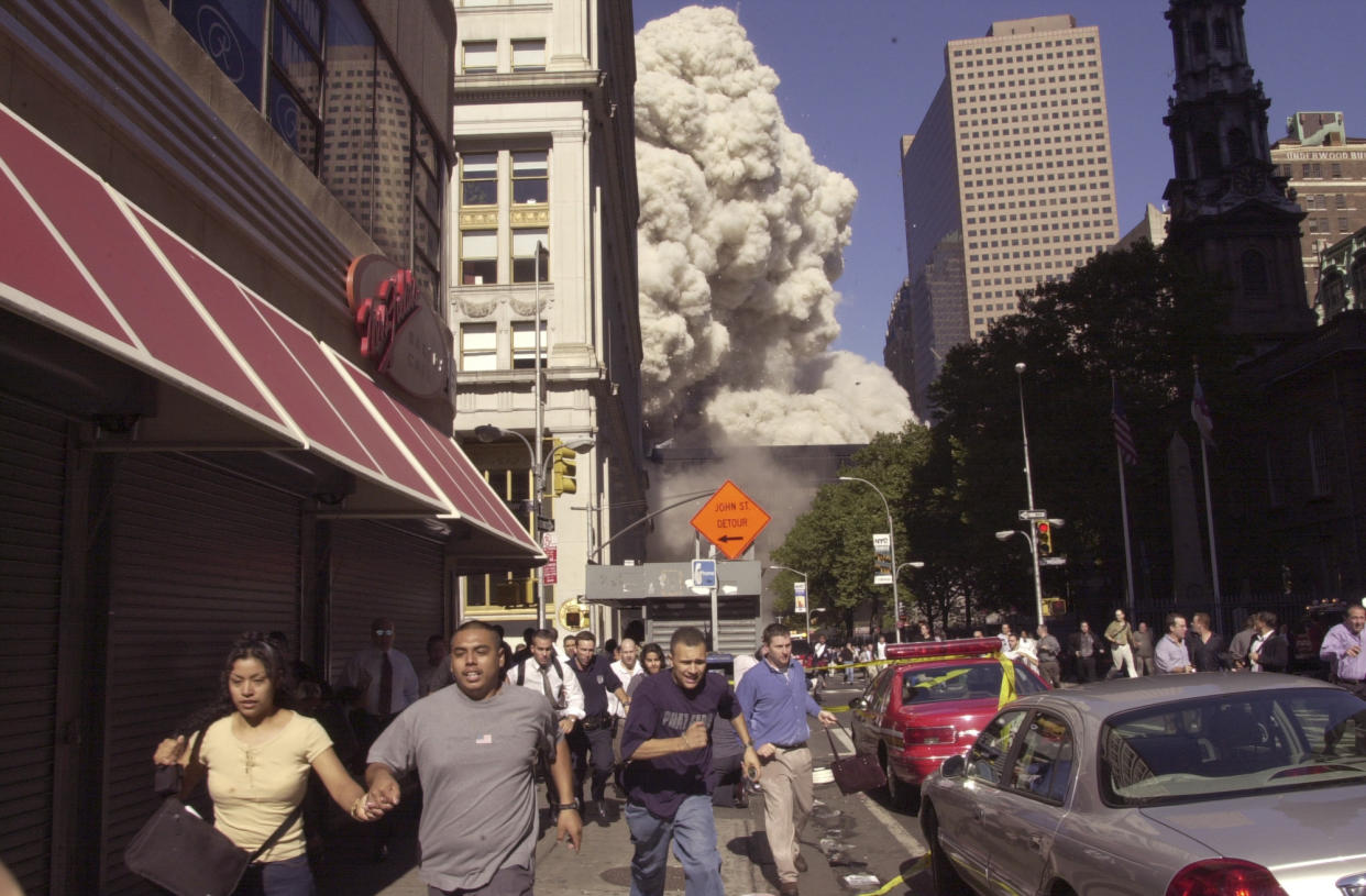 People run from the collapse of the north tower of the World Trade Center in New York, Sept. 11, 2001. (Suzanne Plunkett/AP)