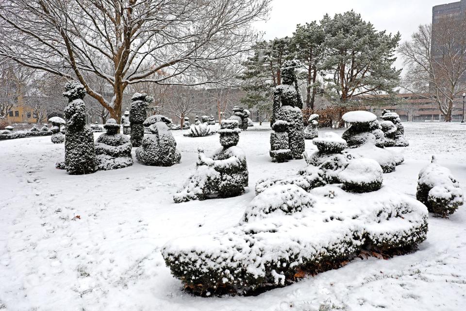 In this December 2020 file photo, Topiary Garden figures located in the Old Deaf School Park are blanketed with snow. The garden, designed by James Mason, is based on a Georges Seurat painting titled "A Sunday Afternoon on the Island of La Grande Jatte."