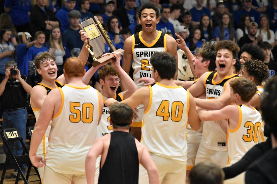 Carter Crews and Kannon Chase lift the sectional trophy as they're mobbed by teammates.