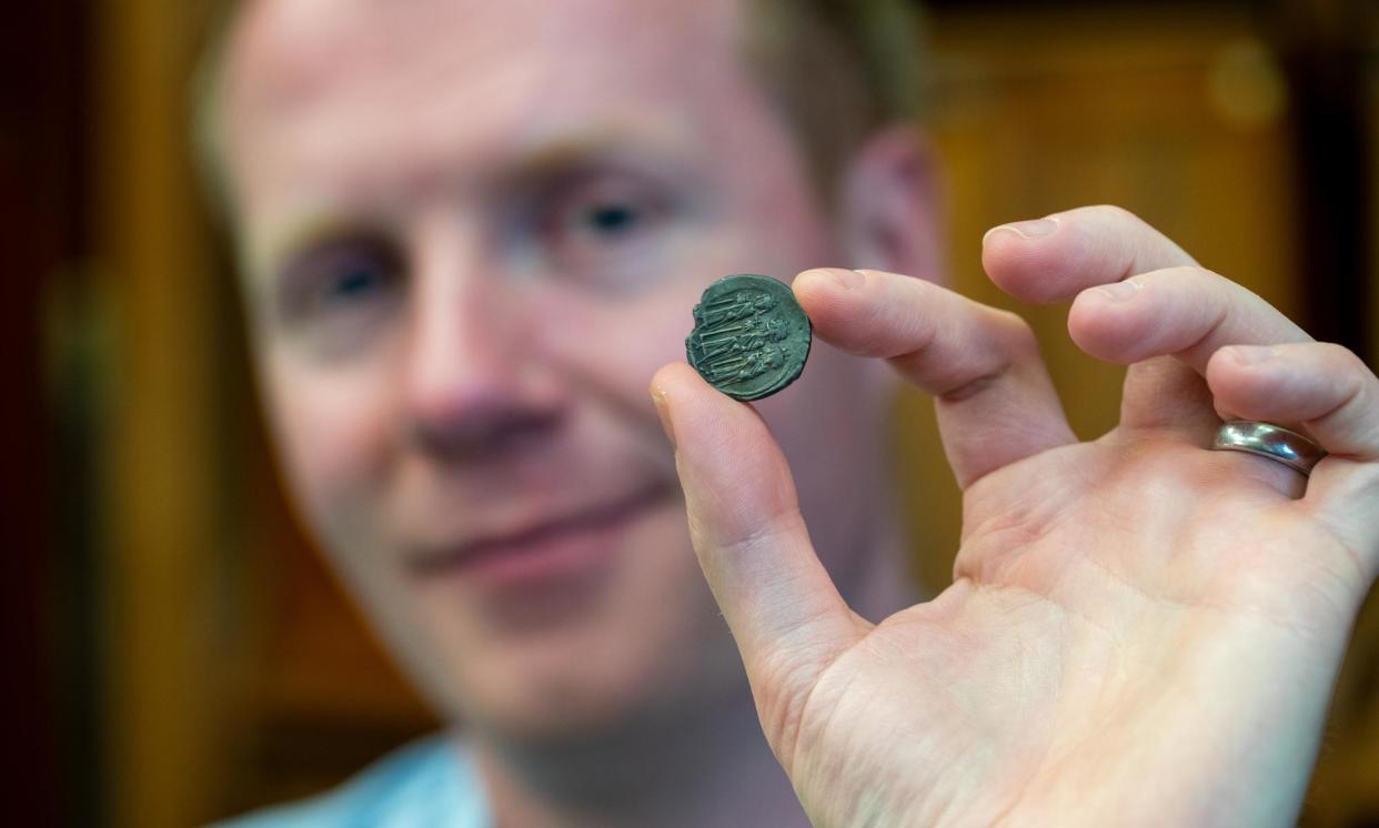 <span>Prof Rory Naismith holds a Byzantine silver coin in the Fitzwilliam Museum, Cambridge.</span><span>Photograph: Adam Page</span>