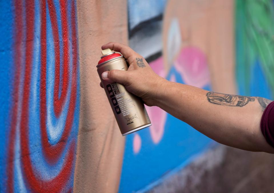 Martinez works on his new mural. When he saw the original was painted over, “it hurt. I felt like they’d destroyed part of me.”