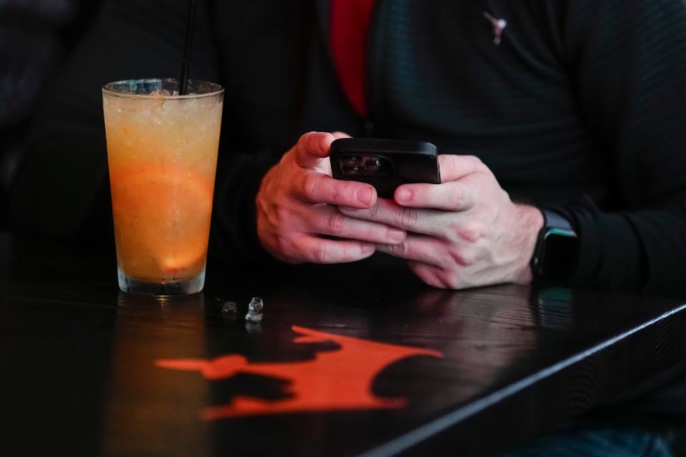 Guests use the DraftKings app to win prizes during the grand opening of DraftKings Sports & Social in the Short North.