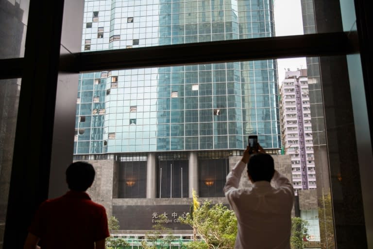 Office workers take photos of blown out windows in a commercial building a day after Typhoon Mangkhut hit Hong Kong