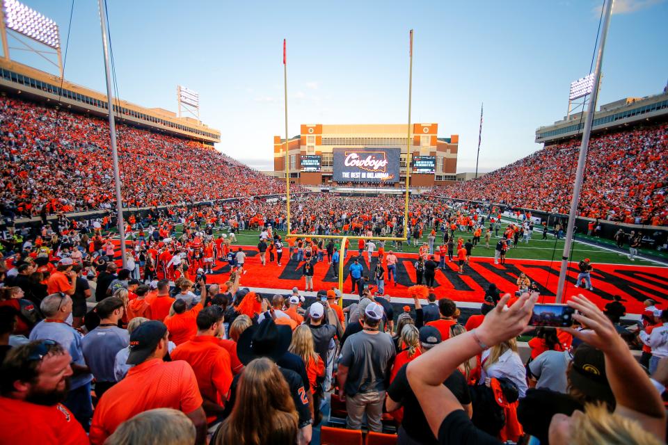 OSU fans storm the field during a Bedlam college football game between the Oklahoma State University Cowboys (OSU) and the University of Oklahoma Sooners (OU) at Boone Pickens Stadium in Stillwater, Okla., Saturday, Nov. 4, 2023.