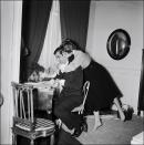 <p>Brigitte Bardot wraps her arms around her husband, French director Roger Vadim, while he works at their Parisian pad. </p>
