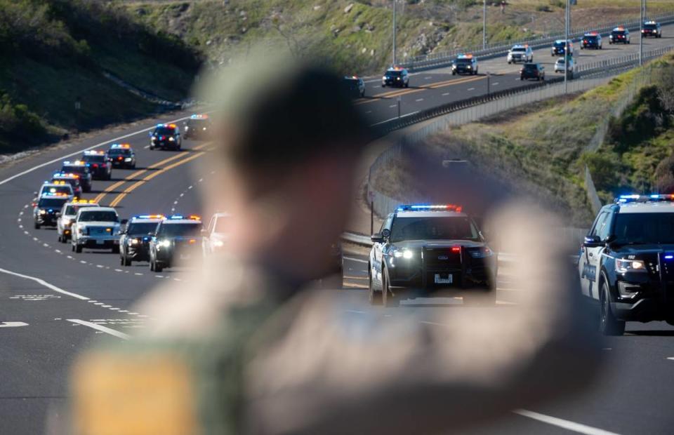 California State Park Ranger Jonathan Geneste salutes as the funeral procession for Elk Grove police officer Tyler Lenehan crosses the Folsom Lake Crossing bridge on its way to his final resting place in the community of Rescue on Feb. 1, 2022. Paul Kitagaki Jr./pkitagaki@sacbee.com
