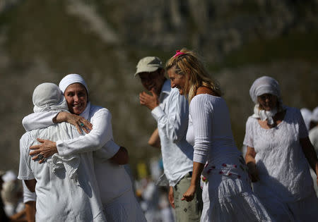 Followers of the Universal White Brotherhood, an esoteric society that combines Christianity and Indian mysticism set up by Bulgarian Peter Deunov in the 1920s, congratulate each other at the end of a dance-like ritual called "paneurhythmy" in Rila Mountain, Bulgaria, August 19, 2017. REUTERS/Stoyan Nenov