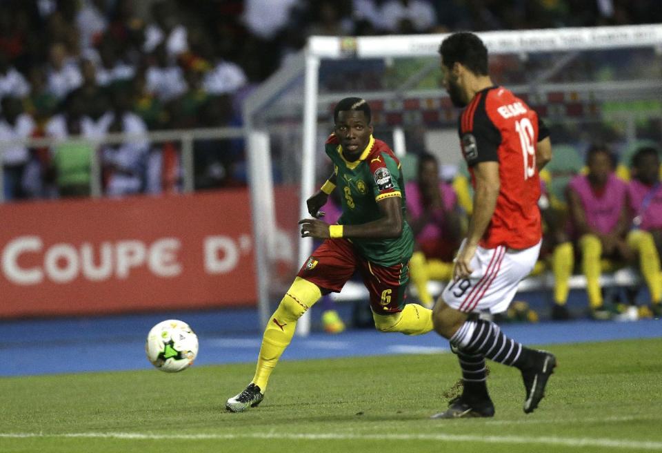 Cameroon's Ambroise Oyongo, left, and Egypt's Abdallah Said Bekhit run for the ball during the African Cup of Nations final soccer match between Egypt and Cameroon at the Stade de l'Amitie, in Libreville, Gabon, Sunday, Feb. 5, 2017. (AP Photo/Sunday Alamba)