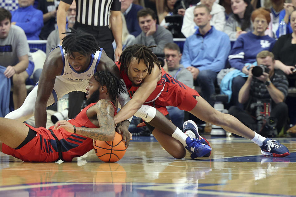 Kentucky's Chris Livingston, top left, and Duquesne's Dae Dae Grant, bottom left, and Duquesne's Joe Reece, right, scramble for the ball during the first half of an NCAA college basketball game in Lexington, Ky., Friday, Nov. 11, 2022. (AP Photo/James Crisp)